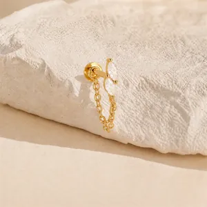 Elegant detail of 16G gold cartilage stud earring with marquise stones and chain