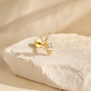 Close-up of gold-plated leaf vine cartilage stud with sparkling marquise stones
