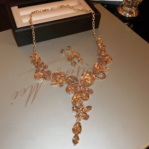 Elegant luxury gold jewelry set featuring teardrop crystal floral necklace and earrings