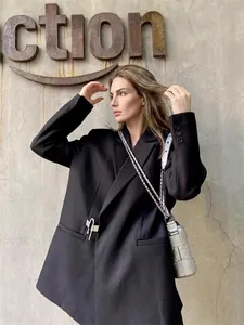 Elegante blazer casual negro de gran tamaño con un detalle de pin de metal plateado