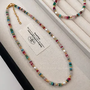 Detailed view of a rainbow natural stone necklace with freshwater pearls on a tray.