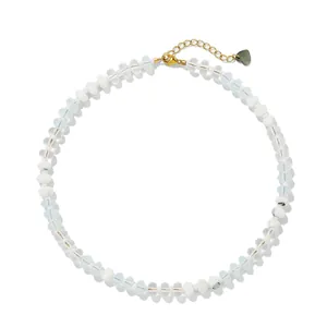 Macro detail of a colorful chalcedony flat bead necklace featuring a gold heart charm
