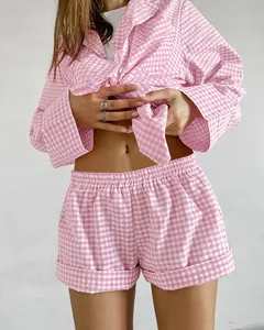 Close-up view of a pink gingham pajama set featuring long sleeve shirt and shorts
