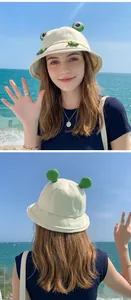 Cute frog bucket hat for women in outdoor beach setting with sun protection features.