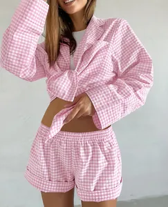 Cozy pink gingham pajama set featuring a tied long-sleeve top and matching shorts