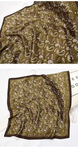 Detail of retro paisley print on olive green silk square scarf with satin finish