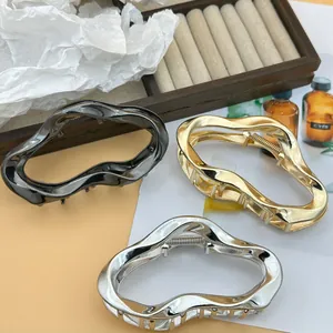 Three large irregular wavy metallic hair claw clips in gold silver and gunmetal finish