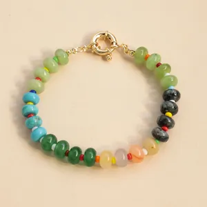 Macro view of a vibrant candy-colored natural stone beaded bracelet with gold clasp