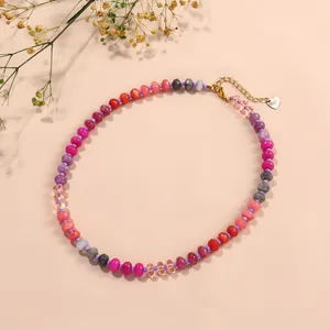 Detailed view of colorful chalcedony bead necklace with gold chain and heart charm