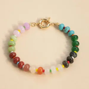 Close-up of candy-colored natural stone bead bracelet with gold spring clasp