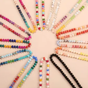 Array of colorful flat bead necklaces in a rainbow radial layout on peach background