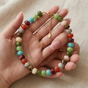 Macro detail of a colorful dopamine style resin beaded necklace with gold chain