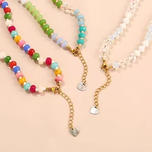 Detailed view of handmade colorful bead necklaces with gold chains and heart pendants