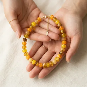 Macro detail of dopamine style necklace with bright orange and yellow beads.