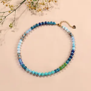 Close-up detail of a colorful chalcedony abacus bead necklace featuring a gold heart charm