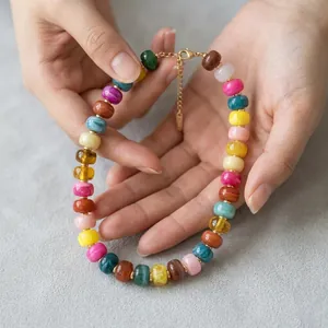 Macro detail of a vibrant summer vacation dopamine resin beaded necklace in hand