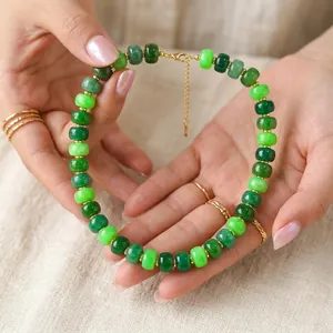 Close-up detail of vibrant green resin beaded necklace with a gold extension chain