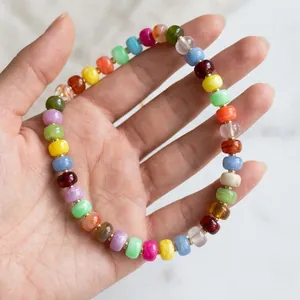 Detailed view of a vibrant dopamine colorful resin beaded bracelet on a woman's hand
