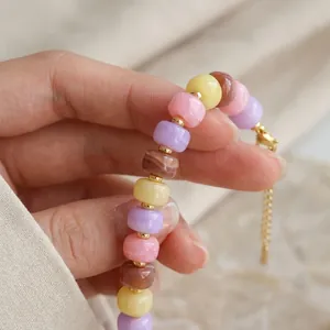 Detailed macro view of colorful high-gloss resin beads and a golden metal clasp.