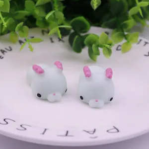 Close-up view of two cute white rabbit squishy toys on a white ceramic plate
