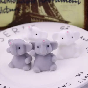 Close-up macro view of cute grey and white elephant TPR squishy toys on a plate