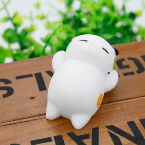 Macro view of a cute white cat squishy toy resting on a rustic wooden board background.