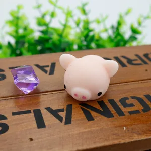 Close-up macro detail view of a cute pink pig squishy toy resting on a wooden box.