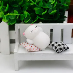 Close-up of a cute white squishy cat toy resting on a miniature white wooden bench