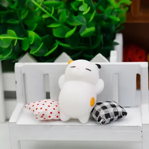 Cute white cat squishy stress relief toy sitting on a tiny bench with decorative pillows