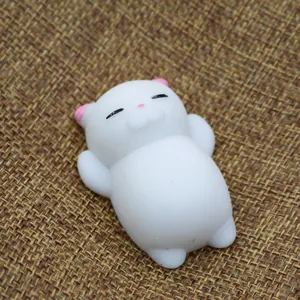 Close-up view of a cute white kitten Mochi squishy stress relief toy on a brown woven mat