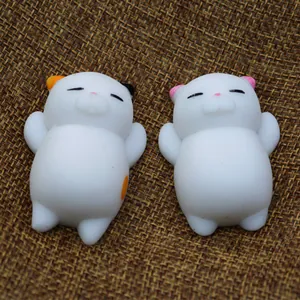 Detailed view of two cute white cat mochi squishies on brown burlap texture background.