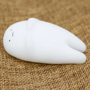 Macro view of a white TPR squishy stress relief toy with a minimalist cute character face