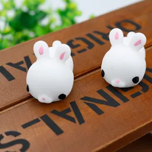 Macro view of cute white rabbit TPR squishy toys placed on a rustic wooden surface background