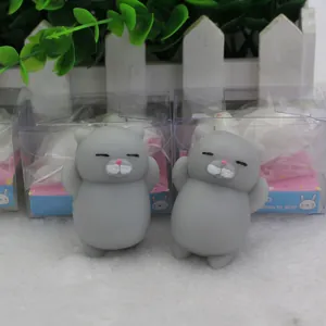 Two grey TPR squishy cat decompression toys displayed on a soft white fluffy surface