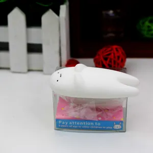 Macro view of a white TPR animal squishy stress relief toy sitting on a clear box
