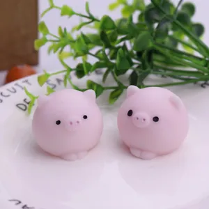 Detail of two pink pig squishy stress relief toys placed on a white ceramic plate.