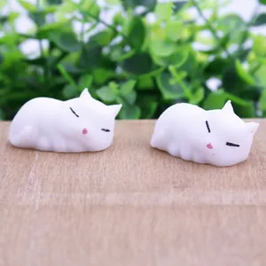 Close-up macro detail of two soft white cat-shaped TPR squishy decompression toys on wood