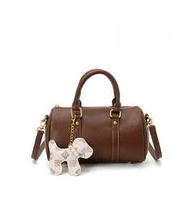 Fashionable brown Boston pillow bag with cute dog charm and gold hardware detail