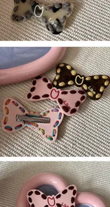 Close-up of Y2K style bow hair clips with woven thread details and cat metallic accent.