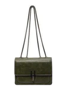 Vintage green crossbody bag with metal chain strap and elegant clasp.