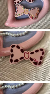 Detail view of pink Y2K bow hair clip with cute embroidery and Like text logo detail