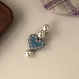 Detailed close-up view of a sweet blue heart hair clip with pearls and polka dots decoration