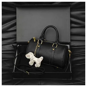 Elegant black Boston pillow bag for women with golden hardware and dog charm in a gift box