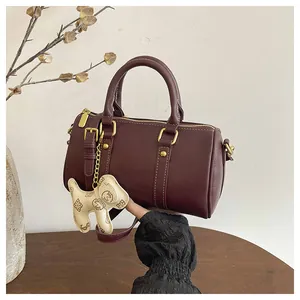 Women's burgundy Boston pillow bag with cute dog charm detail, stylish crossbody handbag