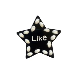 Cool black star-shaped hair clip with white yarn edges and Like lettering detail