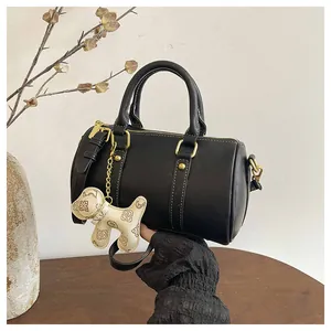 Elegant black faux leather Boston pillow handbag featuring a cute dog charm and gold hardware