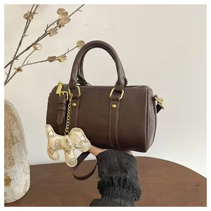 Premium brown Boston pillow bag for women with gold hardware and a cute dog charm