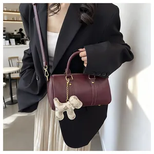 Elegant burgundy Boston pillow bag with cute puppy charm shown in a lifestyle setting