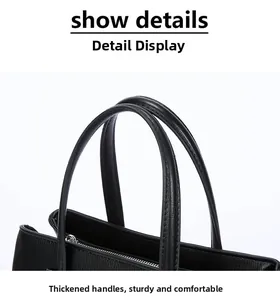 Detailed view showing the thickened handles of a black leather commuter tote bag