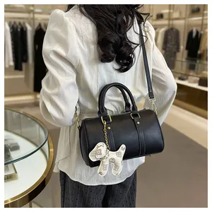 Elegant black Boston pillow bag for women with a stylish puppy charm and gold hardware
